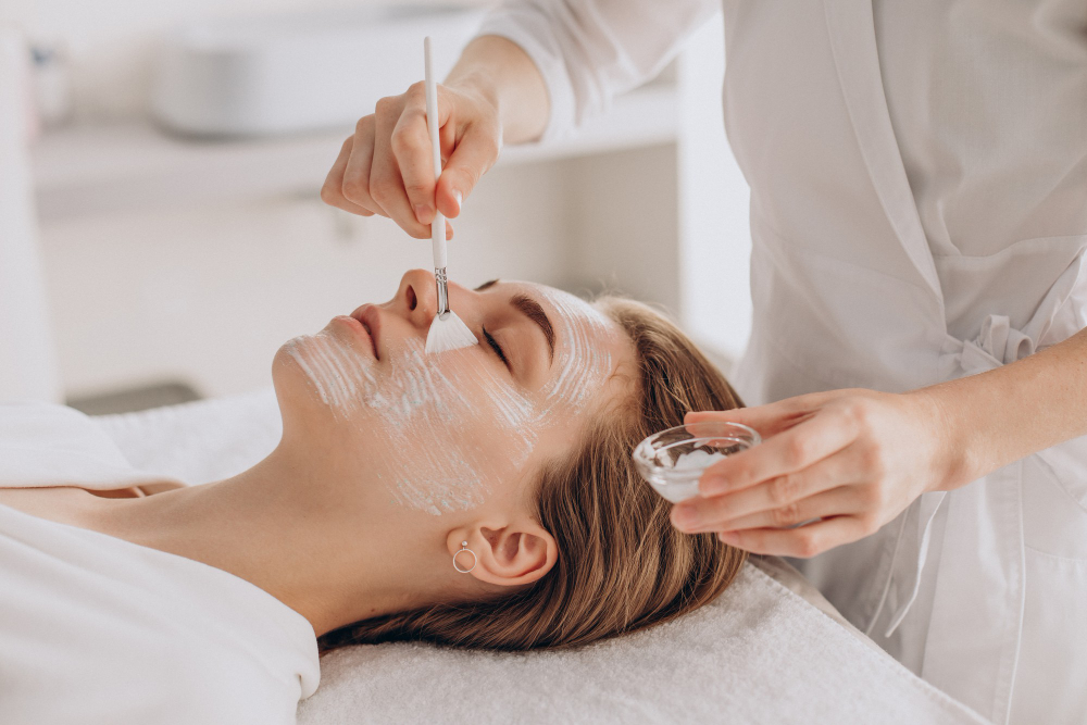 Woman receiving a chemical peel treatment with a facial mask applied, in a med spa setting focused on skin rejuvenation.